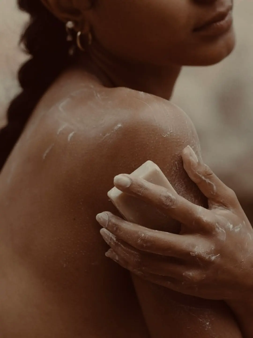 A woman relaxing in the water while holding a handcrafted soap bar
